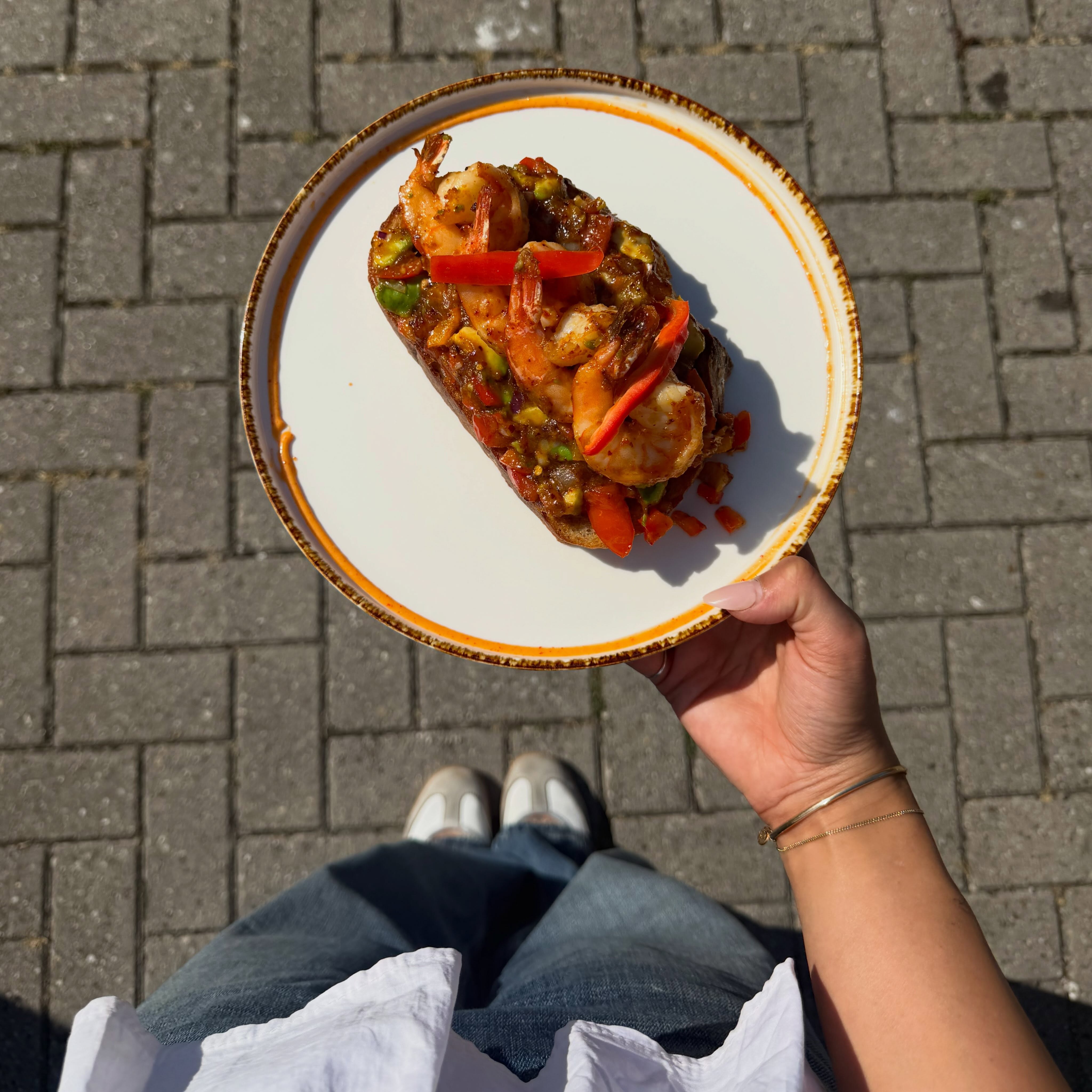 Prawn-avocado toast op een bord in de zon